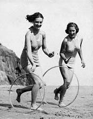 par de chicas jugando aro en la playa